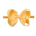 Detailed close-up of a large pale orange ribbed bow on a soft nylon elastic headband - Pale Orange