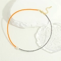 Detail of bohemian necklace with orange glass beads and a white freshwater pearl pendant - Orange And Black (NE2143-C)