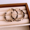 Detail shot of leopard print wrapped hoop earrings in a beige velvet jewelry organizer - 82# Silver Earring Post - Brown - Leopard Woven Fluid Hoop
