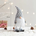35cm plush Christmas gnome with gray star hat and skis on warm festive background - Skiing Gnome (Grey Pattern Hat)