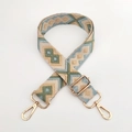 Close-up of geometric diamond jacquard weaving and gold metal hooks on a wide bag strap - Light Khaki Green Blue