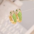 Macro shot of gold snake earring featuring green enamel scales and cubic zirconia accents - Green