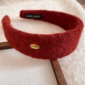 Detail of red plush wide headband featuring a gold Korea metal tag and handmade label - Brown