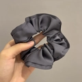 Detail van donkergrijze satijnen scrunchie met glanzende textuur en ruches - Marineblauw