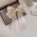 Gros plan d'une pince à cheveux nœud en tulle crème dans un coffret en bois - Blanc Cassé