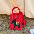 Detail of red knitted mini phone bag featuring a cartoon horse design on green grass - Money Horse Red