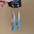 Macro-opname van lange kwastjes oorbellen met druppelzirkonia in vintage hofstijl - Blauw