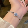 Detailed view of silver flower bracelet with zircon and pearls worn on a wrist - S528 Silver