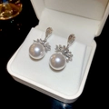 Macro detail of silver vintage earrings with large pearls and sparkling zircon flowers - Silver (Silver Pin)