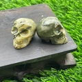 2.8cm green quartz crystal skull carvings displayed on a rustic wooden base - Leopard Jasper
