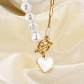 Collar de colgante de corazón dorado con perlas y cadena de clip sobre fondo de seda blanca - Dorado