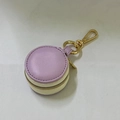 Close-up of a circular lilac and beige jewelry travel case with a golden keychain hook - 5*5*3cm / Purple