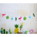 Tropische Party-Girlande mit rosa Flamingos und grünen Monstera-Blättern vor weißer Wand - Flamingo & Blaue Blätter