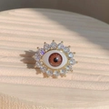 Macro view of gold evil eye ring featuring brown resin iris and sparkling zircon stones - Adjustable Open / Brown