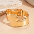 Detail eines kühnen vergoldeten breiten geometrischen Manschettenarmbands mit Scharnier - Goldener Überkreuzter Offener Armreif