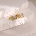 Macro shot of 18K gold plated rectangular earring with zircon on white stone - Clear