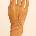 Bohemian gold chain finger bracelet with white beads worn by a model on a neutral background - 18kc Gold 8473