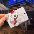 Gros plan d'une pince à cheveux ours polaire en peluche avec bonnet de Noël rouge - Ours Blanc en Tissu Éponge