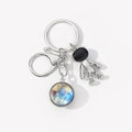 Detail of metal astronaut keychain featuring a star pattern glass pendant on white background - Deep Space Nebula-6