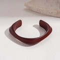 Macro detail of amber resin open cuff bracelet with asymmetrical geometric design - 3# Asymmetric Streamlined Open (Reddish Brown)