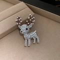 Sparkling reindeer brooch with white rhinestones and brown enamel antlers on a tray - Rhinestone Enamel Reindeer Brooch