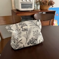 Détail du tissu jacquard à plantes noires sur une trousse de toilette beige zippée - Gris Argenté Avec Branches Fleuries