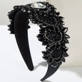 Dettaglio ravvicinato del cerchietto largo in velluto con fiori in cristallo nero 3D - Nero