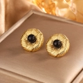 Macro shot of gold spiral weave earrings with black beads on a luxury velvet box - Gold + Black Pearl