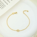 Detailed macro view of a gold-plated beaded bracelet featuring a pavé-set zircon center - Oval Zircon Style (B0028G)