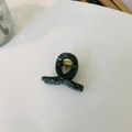 Detailaufnahme einer glänzenden dunkelgrünen Haarklammer mit einer starken Goldfeder - Mini Schmetterlingsschnalle X-Form / Gelee Dunkelgrün