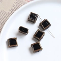 Detail of vintage square black beads with gold sand edges on white ceramic plate - Black