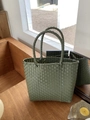 Nahaufnahme der grünen Strohtasche auf Holzmöbeln im natürlichen Sonnenlicht - Mini / Dunkelgrün