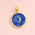 Dettaglio di un ciondolo rotondo in lega dorata con smalto blu navy e motivo a luna - Mezzaluna Blu