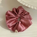Pink satin scrunchie with a single pearl accent on a minimalist white background - Pink