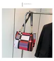Detail der geometrischen Color-Block-Tasche mit goldener Kette auf einem Verkaufsregal - Rosarot