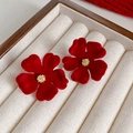 Gros plan de boucles d'oreilles fleurs en velours rouge avec centres dorés sur socle - 7# Tige de boucle d'oreille en argent - Pétales rouges