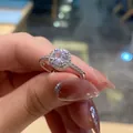 Macro shot of silver halo ring featuring a large round center stone and diamond side accents - TJZ197-Round Halo Cluster