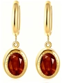 Detailed macro view of vintage oval red zircon earrings with gold-toned metal base - Orange Red