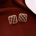 Detailed view of square fabric earrings with brown plaid patterns and gold metal borders - Brown