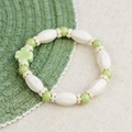 Ceramic bracelet with white oval beads and a green clover charm for women - Green Four-Leaf Clover Style (1656-01) / Green