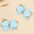 Close-up of light blue fabric hair clips with gold glitter edges and bow design - Sky Blue
