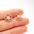 Primer plano de pendientes de flores huecas en oro rosa con detalles de corazones - Oro rosa