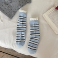 Calcetines de rayas azules y blancas con ribete de volantes en un ambiente acogedor - Azul