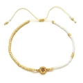 Detail of bohemian beaded bracelet with gold beads, white accents and adjustable cord - Champagne