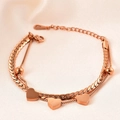 Detail of double-layer rose gold bracelet with heart charms on pink satin background - Rose Gold