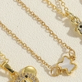 Macro detail of gold-plated choker with pavé zircon bear and white shell butterfly charms - Shell Bear