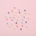 Colorful mixed resin flower beads for DIY jewelry making on a pink background - White