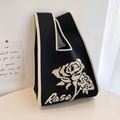 Detail of a chic black and white knitted tote bag with a woven rose pattern and Rose text - Black Single Rose