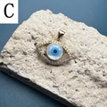 Detailed view of evil eye pendant with gold plating and cubic zirconia on rock base - C-Eye