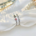 Detailed view of silver minimalist rings with pink zircon and star on white silk cloth - Two-Piece Set / Silver/Pink